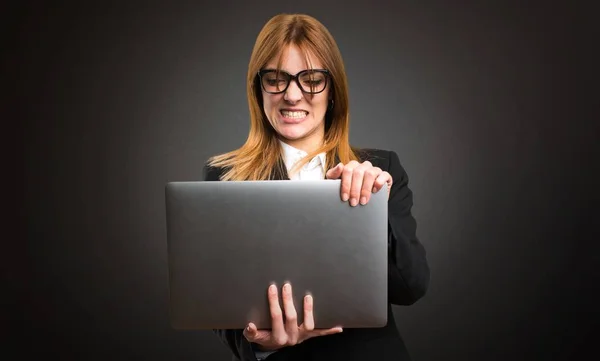 Mladá podnikatelka s notebookem na tmavém pozadí — Stock fotografie