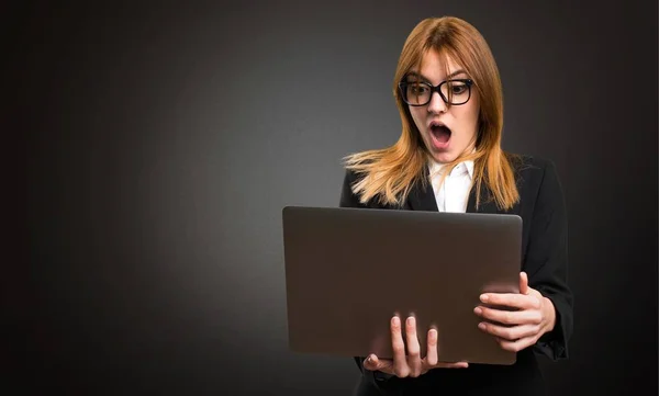 Young business woman with laptop on dark background — Stock Photo, Image