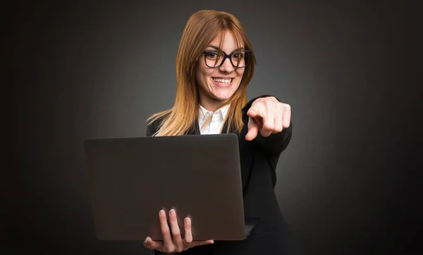 Mladá podnikatelka s notebookem na tmavém pozadí — Stock fotografie