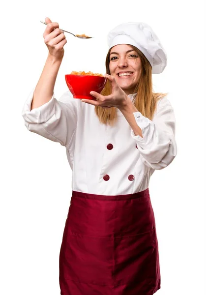 Glücklich schöne Köchin Frau, die Getreide aus einer Schüssel isst — Stockfoto