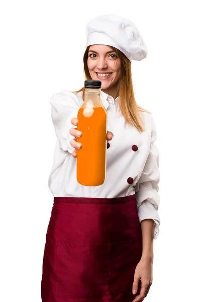 Glücklich schöne Köchin Frau hält einen Orangensaft — Stockfoto