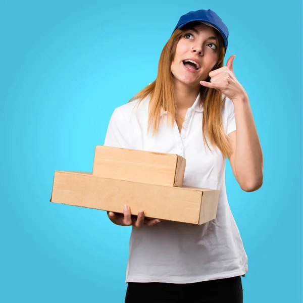 Entrega mulher fazendo telefone gesto no fundo colorido — Fotografia de Stock