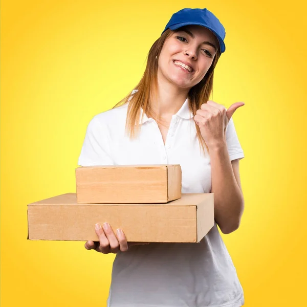 Mulher de entrega com polegar para cima no fundo colorido — Fotografia de Stock