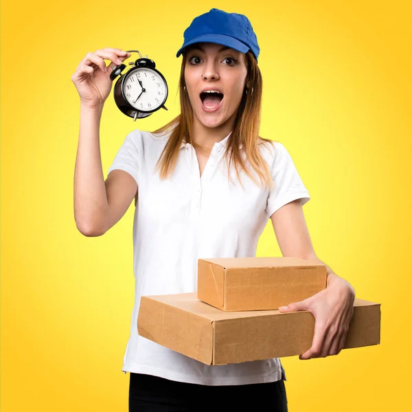 Sorprendido Entrega mujer celebración de reloj vintage en backg colorido — Foto de Stock