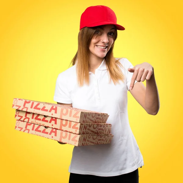 Pizza entrega mujer apuntando hacia abajo en el fondo colorido — Foto de Stock