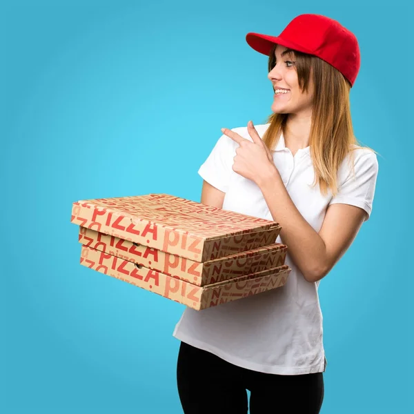 Pizza entrega mulher apontando para trás no fundo colorido — Fotografia de Stock