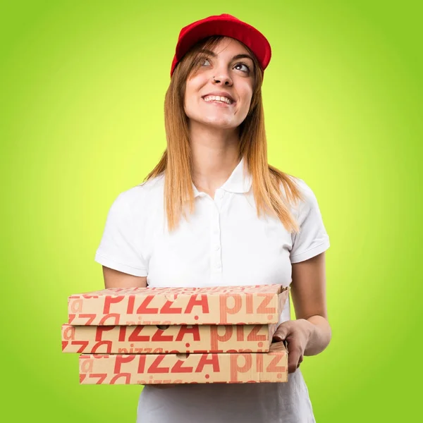 Pizza entrega mulher olhando para cima no fundo colorido — Fotografia de Stock