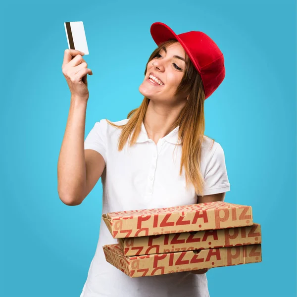 Pizza entrega mulher segurando um cartão de crédito em backgroun colorido — Fotografia de Stock