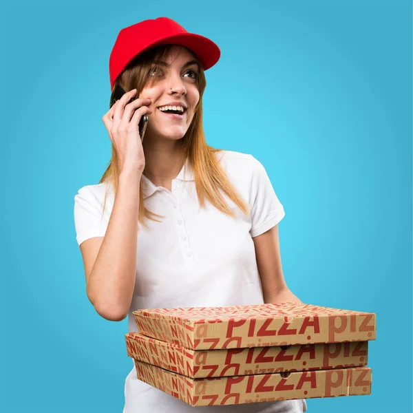 Mulher de entrega de pizza conversando com celular em fundo colorido — Fotografia de Stock