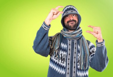 Adam küçük yapma kış giysileri ile renkli arka plan üzerinde oturum