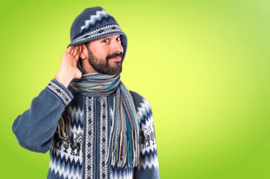 Adam bir şey renkli backgrou üzerinde dinleme kış giysileri ile