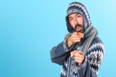 Kış giysileri renkli backgr cephesinde işaret eden adamla