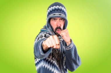 Adam kış giysileri renkli arka plan üzerinde mücadele ile