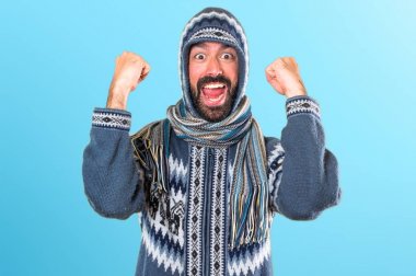 Kış giysileri renkli arka plan üzerinde olan şanslı adam