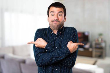 Yakışıklı adam evin içinde şüpheleri laterallerin işaret