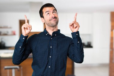 Yakışıklı adam işaret up evin içinde