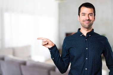 Yakışıklı adam evin içinde lateral işaret