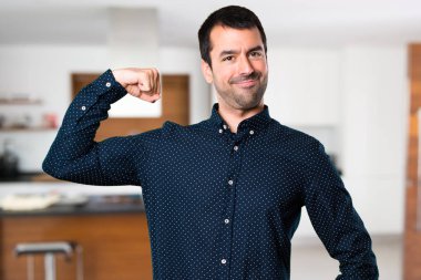 Yakışıklı adam evin içinde güçlü bir jest yapma