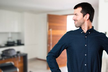 Yakışıklı adam evin içinde yan bakan