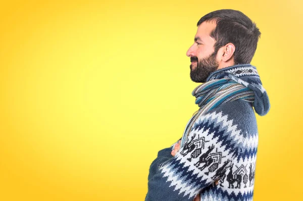 Człowiek z zimowe ubrania patrząc boczne na kolorowe tło — Zdjęcie stockowe