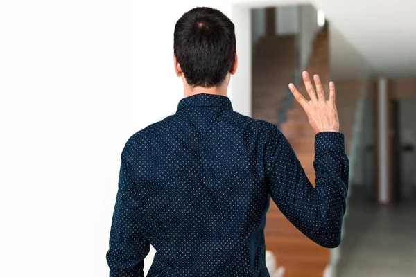 Hombre guapo contando cuatro dentro de la casa —  Fotos de Stock