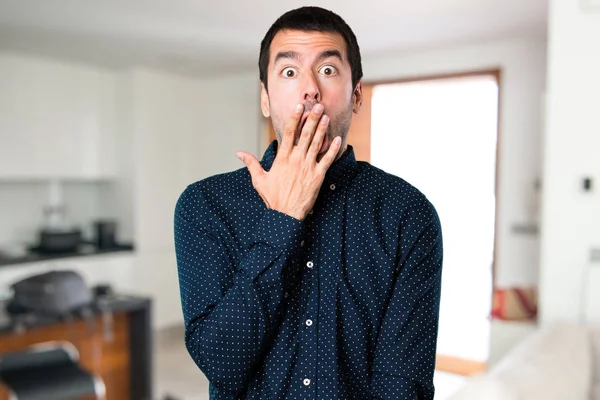Pohledný muž dělat překvapení gesto uvnitř domu — Stock fotografie