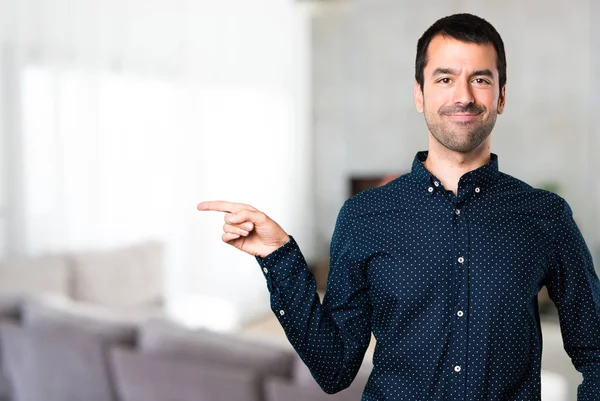 Handsome man pointing to the lateral inside house