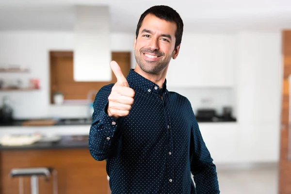 Handsome man with thumb up inside house