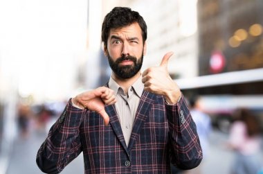 İyi giyimli adam şehirde iyi-kötü işaret yapma