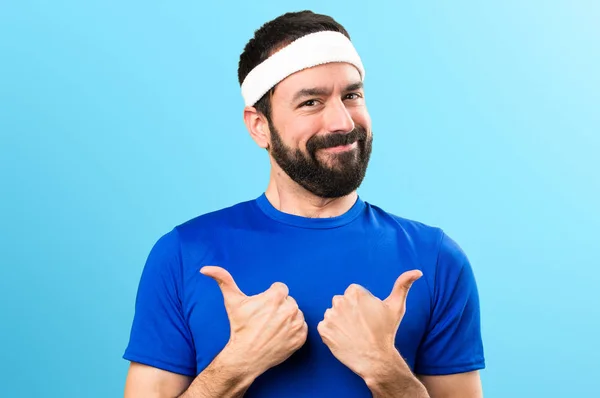 Funny sportsman with thumb up on colorful background — Stock Photo, Image