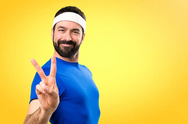 Funny sportsman making victory gesture on colorful background — Stock Photo, Image