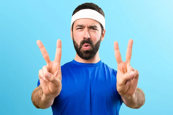 Funny sportsman making victory gesture on colorful background — Stock Photo, Image