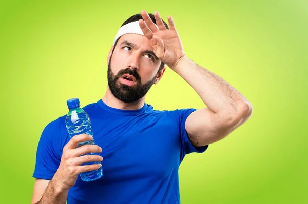 Divertente sportivo con una bottiglia d'acqua su sfondo colorato — Foto Stock