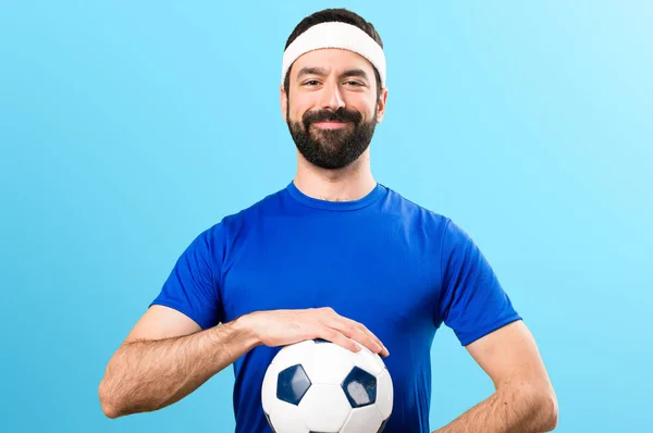 Buon divertente sportivo che tiene un pallone da calcio sul backgrou colorato — Foto Stock