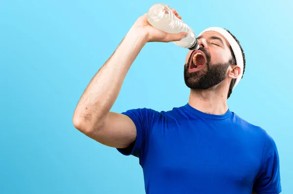 Смешной спортсмен с бутылкой воды на красочном фоне — стоковое фото
