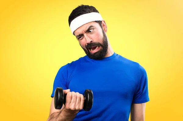 Divertente sportivo che fa sollevamento pesi su sfondo colorato — Foto Stock