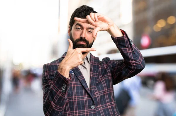 Hombre bien vestido enfocándose con los dedos en la ciudad — Foto de Stock