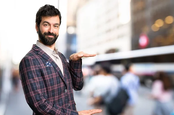 Hombre bien vestido sosteniendo algo en la ciudad — Foto de Stock