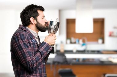 Mutlu iyi giyinmiş bir kupa evin içinde tutan adam