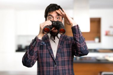 Sürpriz iyi giyimli adam evin içinde dürbünlü