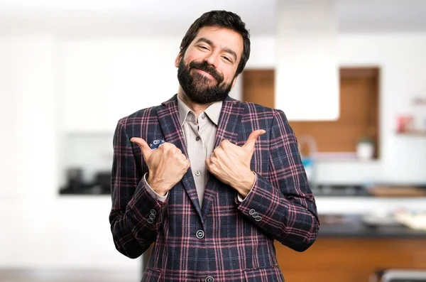 Well dressed man with thumb up inside house