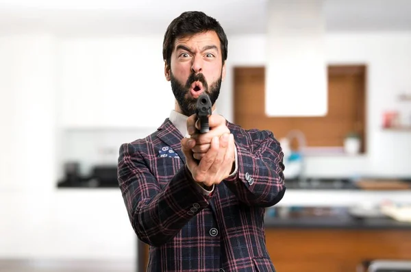 Homem bem vestido atirando com uma pistola dentro da casa — Fotografia de Stock