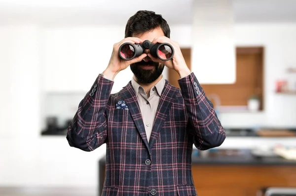 Homem bem vestido com binóculos dentro de casa — Fotografia de Stock