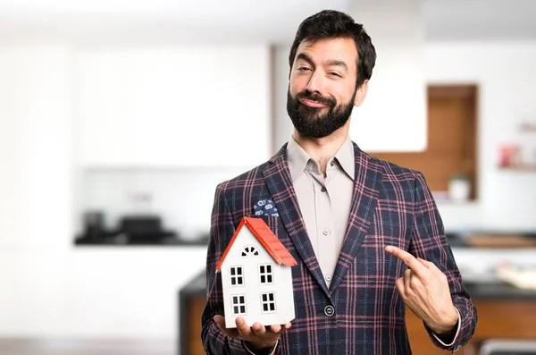 Feliz hombre bien vestido sosteniendo una casita dentro de la casa —  Fotos de Stock