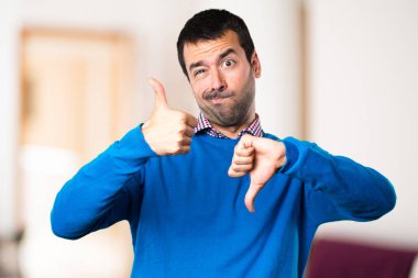 İyi-kötü işaret odaklanmamış arka plan yapma yakışıklı genç