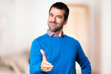 Yakışıklı genç adam odaklanmamış arka plan üzerinde anlaşma