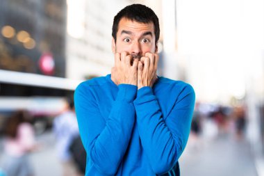 Korkmuş yakışıklı delikanlı odaklanmamış arka plan üzerinde