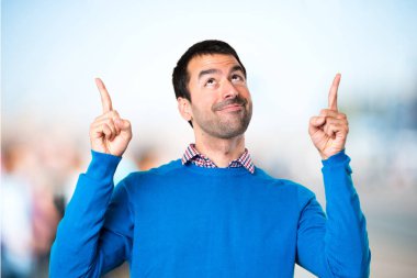 Odaklanmamış arka plan üzerinde yukarıyı yakışıklı genç