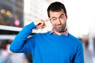 Yakışıklı genç adam odaklanmamış arka plan üzerinde düşünme