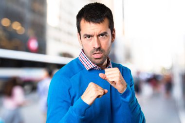 Yakışıklı genç adam odaklanmamış arka plan üzerinde mücadele